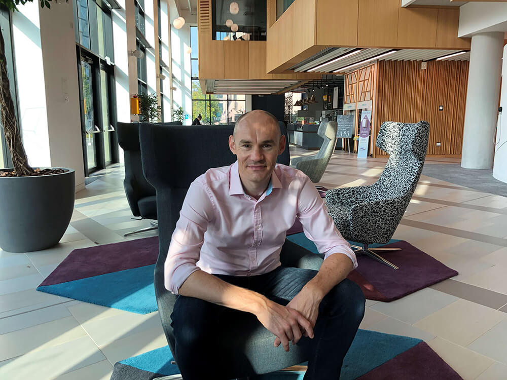 A picture of Andy Jenkins sitting in a chair inside an office